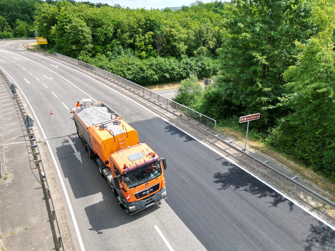 SUT-Einbaufahrzeug der Asphalt-Kolonne auf frisch saniertem Asphalt – Luftaufnahme